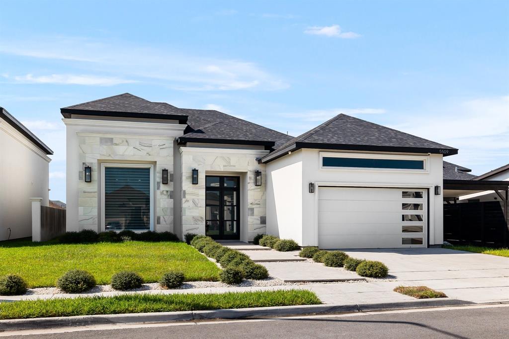 a front view of a house with a yard and garage