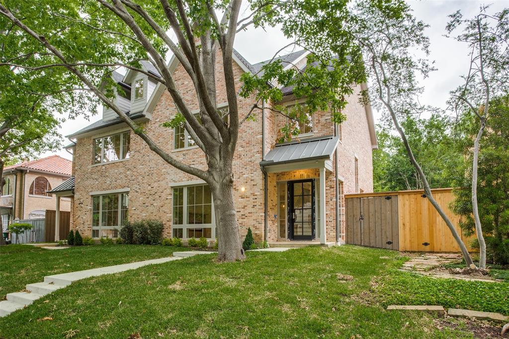 a view of a house with a yard and a large tree