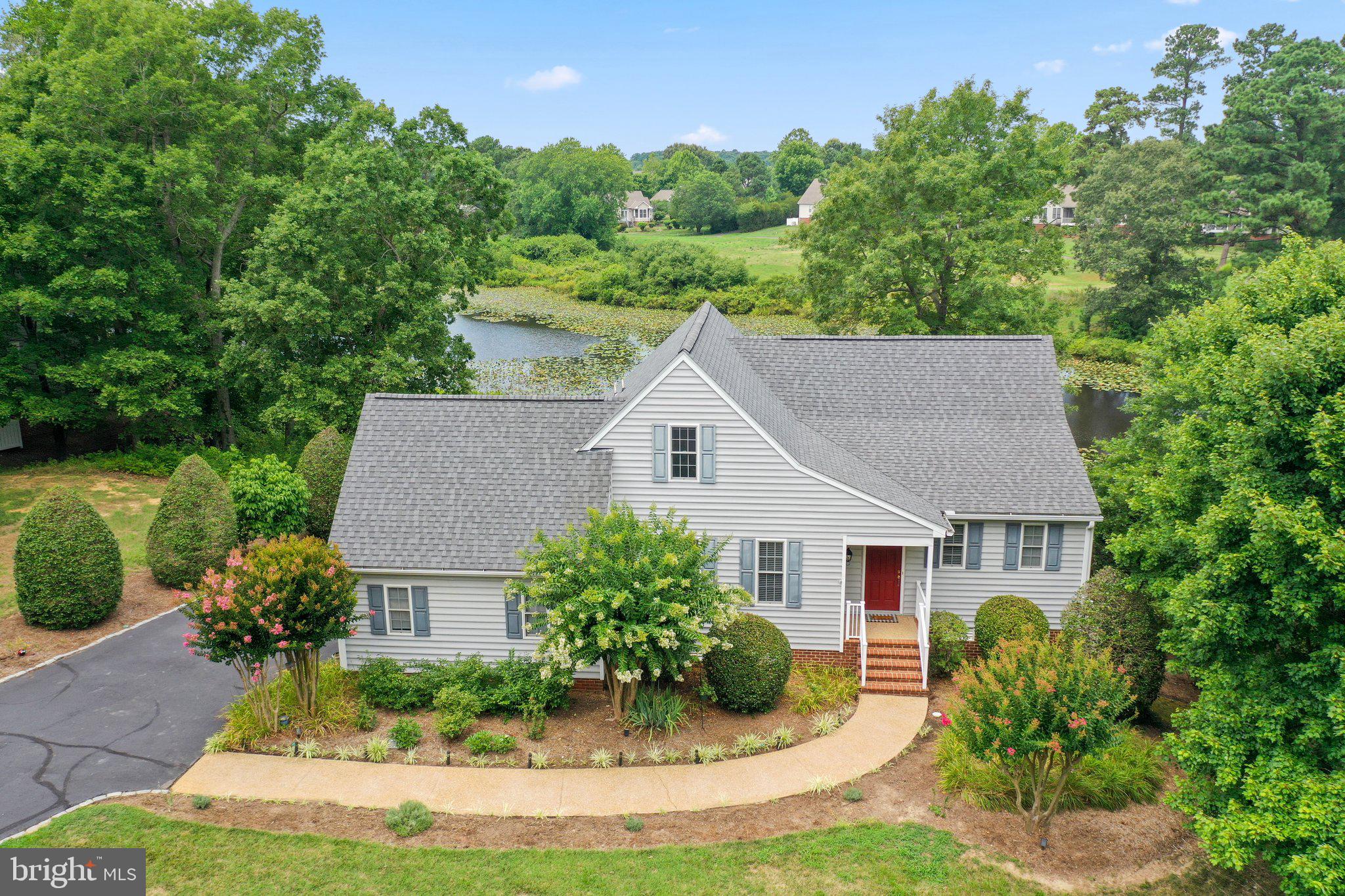 a aerial view of a house with yard and trees in the background