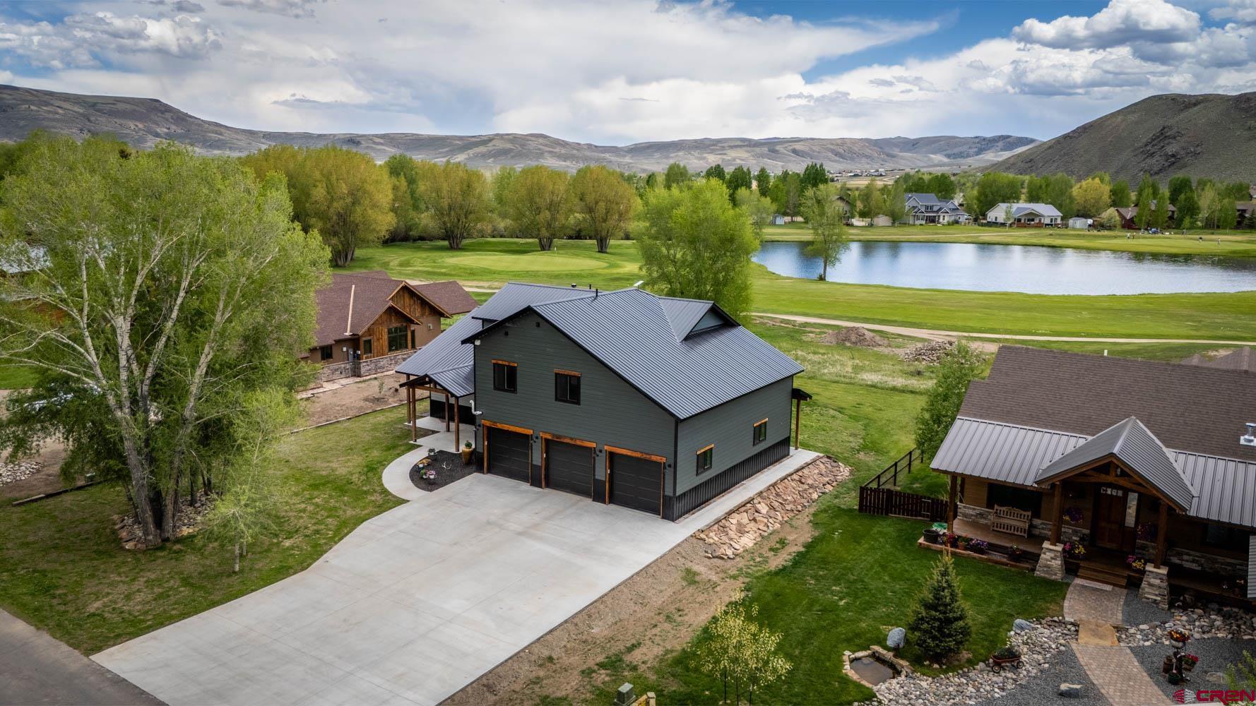 an aerial view of a house with a garden and lake view