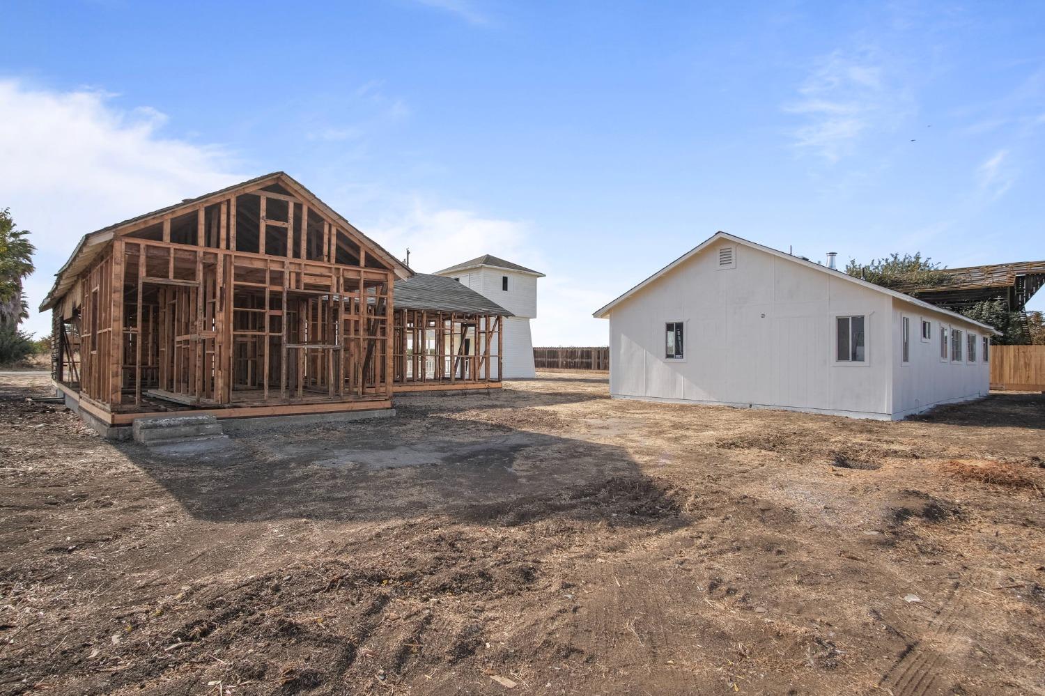 a view of a house with backyard and wooden fence