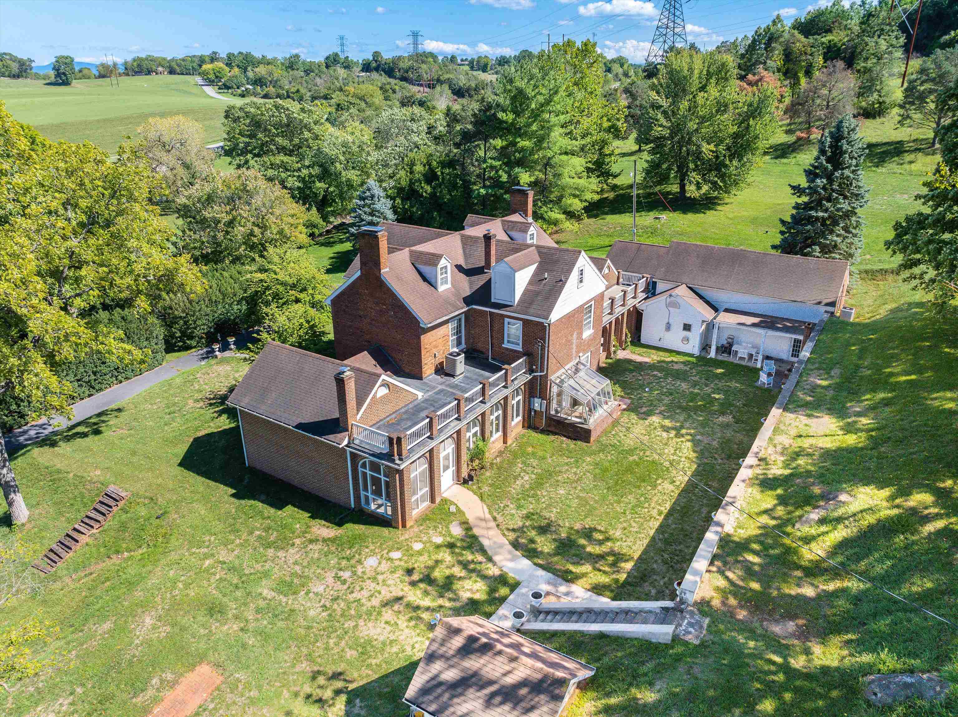 an aerial view of a house with pool big yard and large trees