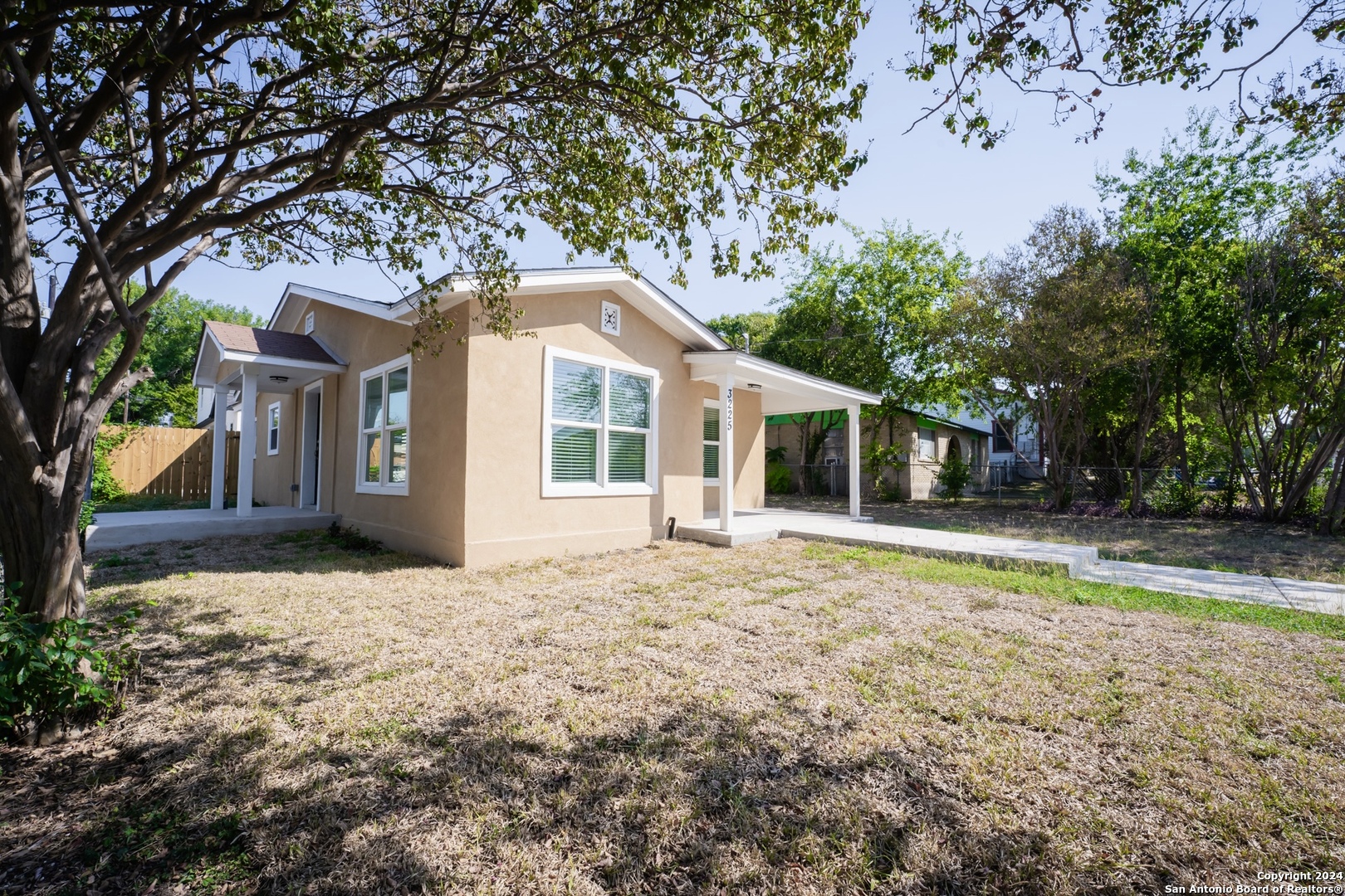 a front view of a house with a yard and trees