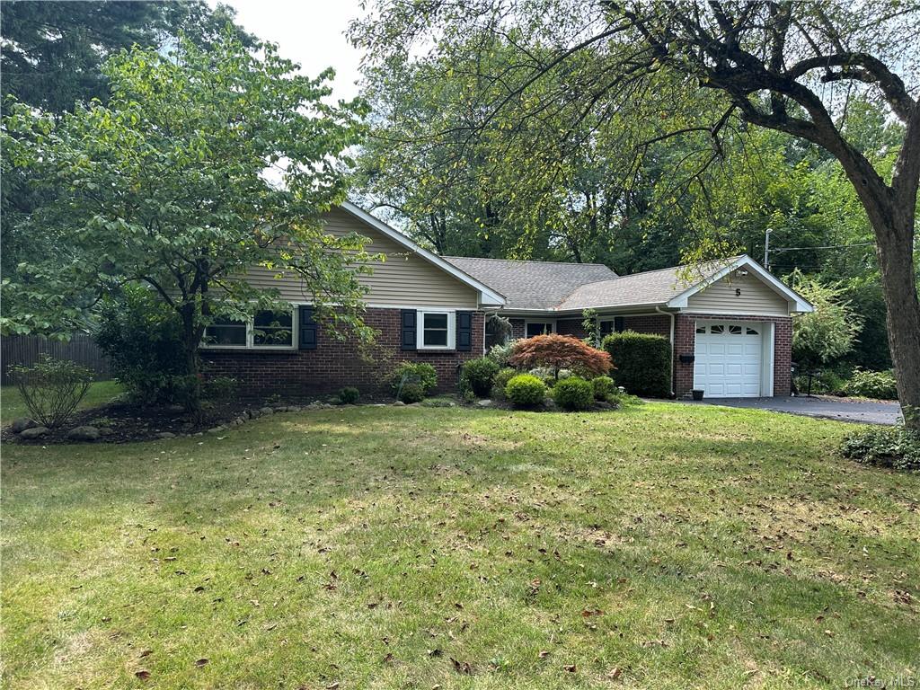 Ranch-style home with a garage and a front lawn