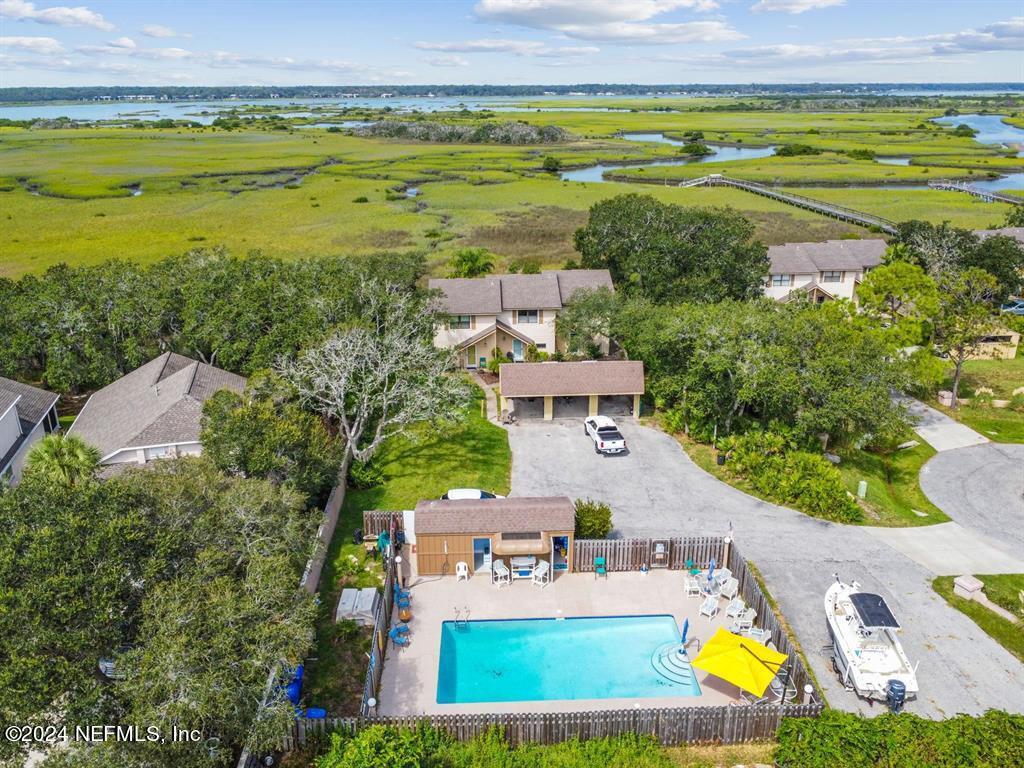 an aerial view of residential houses with outdoor space and swimming pool