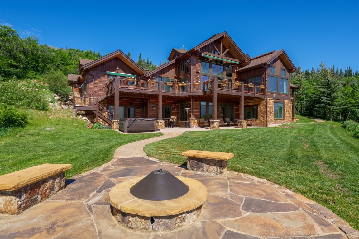 Rear view of house featuring a patio, a deck, and a yard