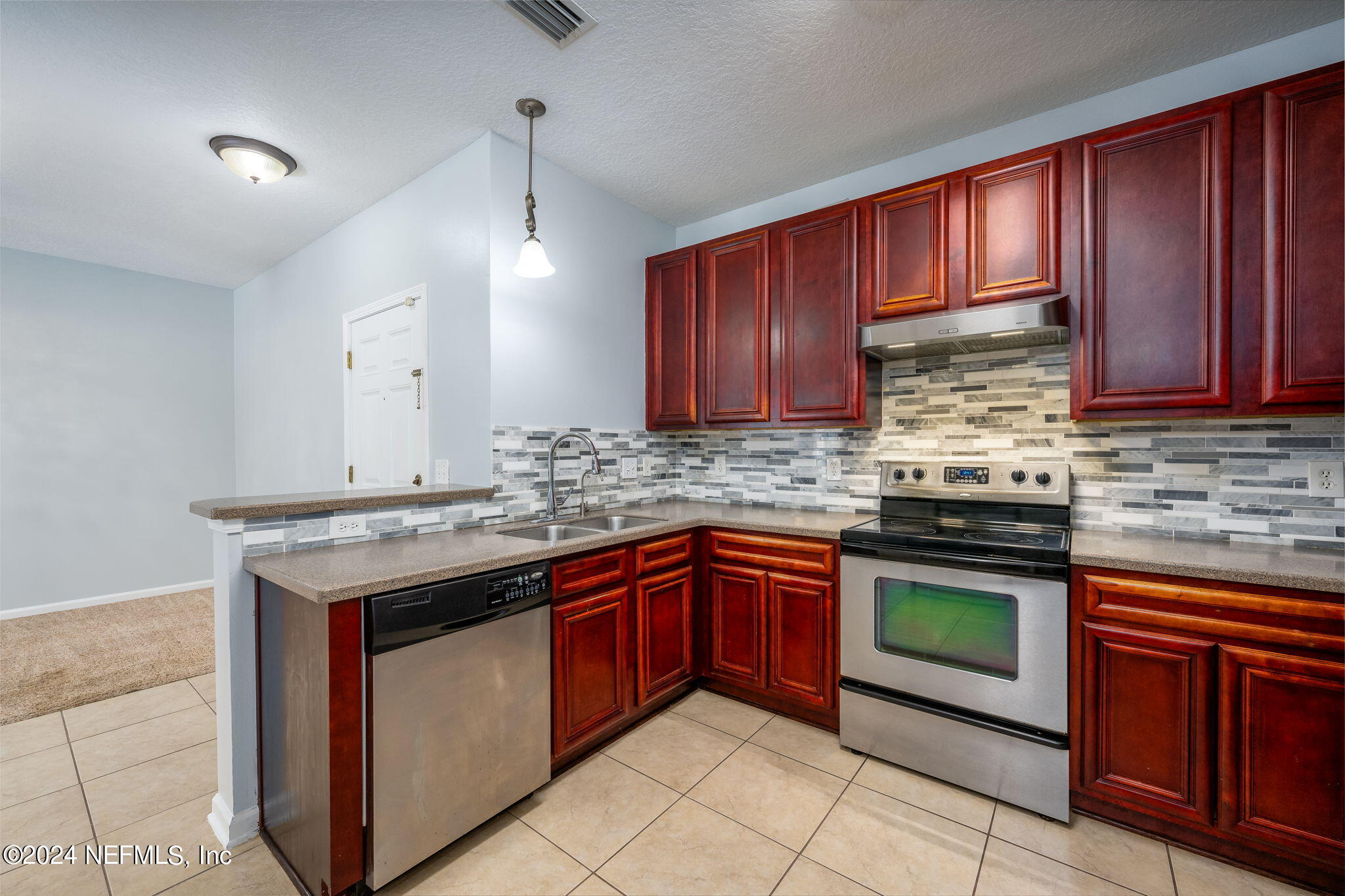 a kitchen with stainless steel appliances granite countertop wooden cabinets stove top oven and sink