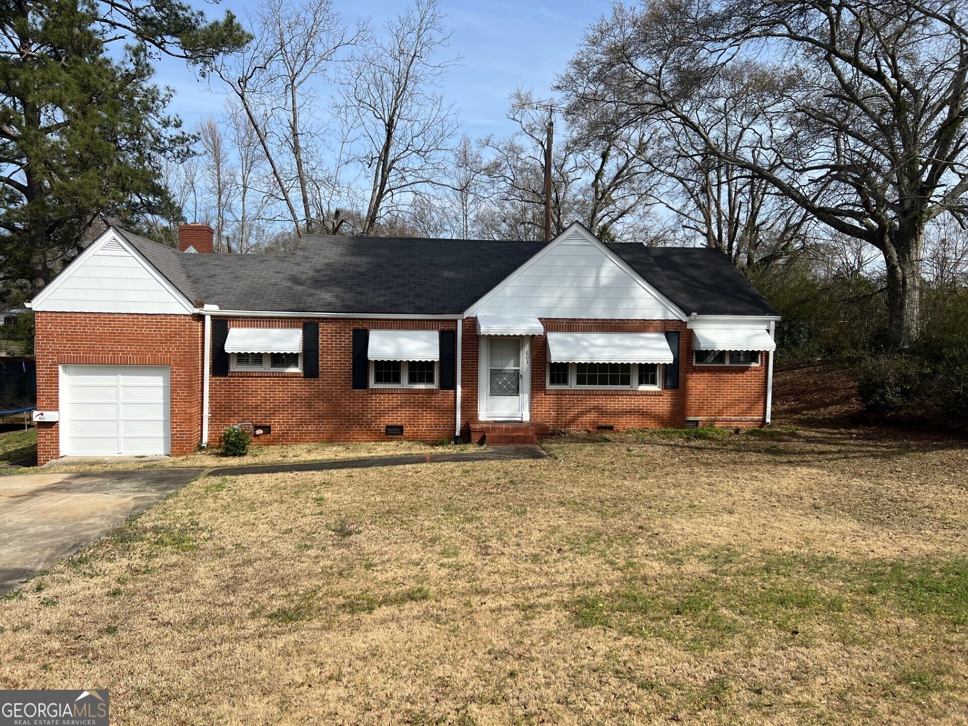 a front view of a house with a garden