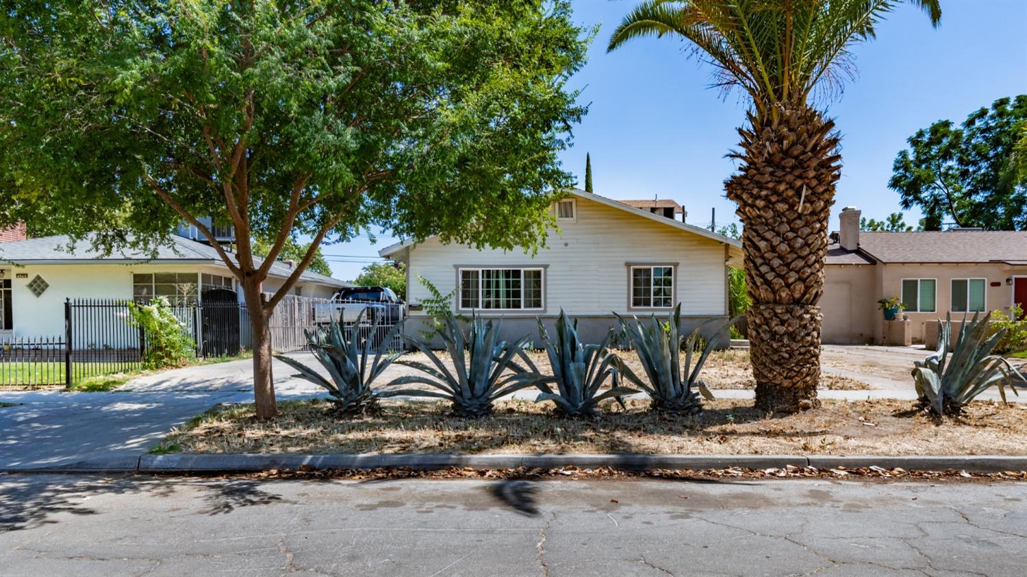 a view of a house with backyard and a tree