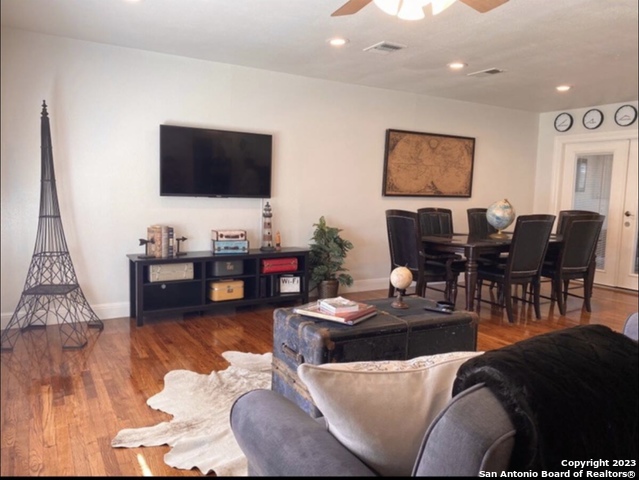 a living room with furniture kitchen view and a flat screen tv