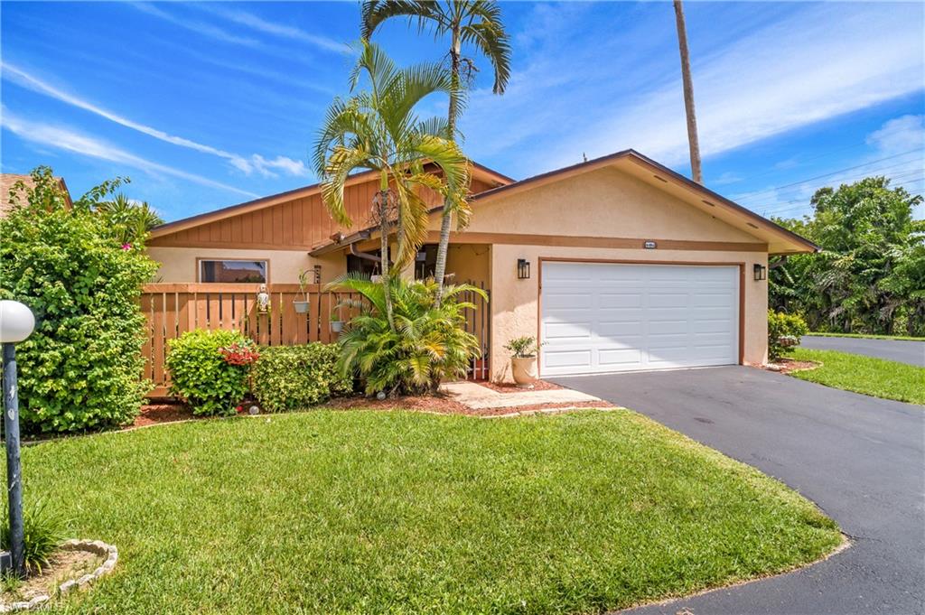 Single story home featuring a garage and a front lawn