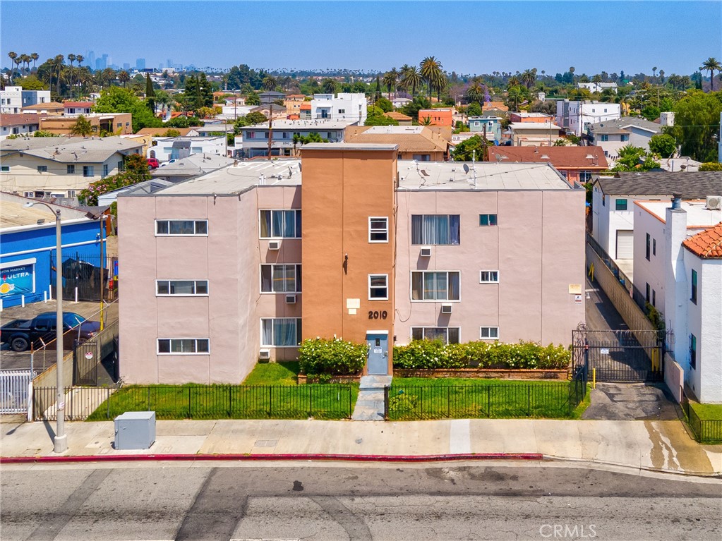 a view of a building with a yard and plants