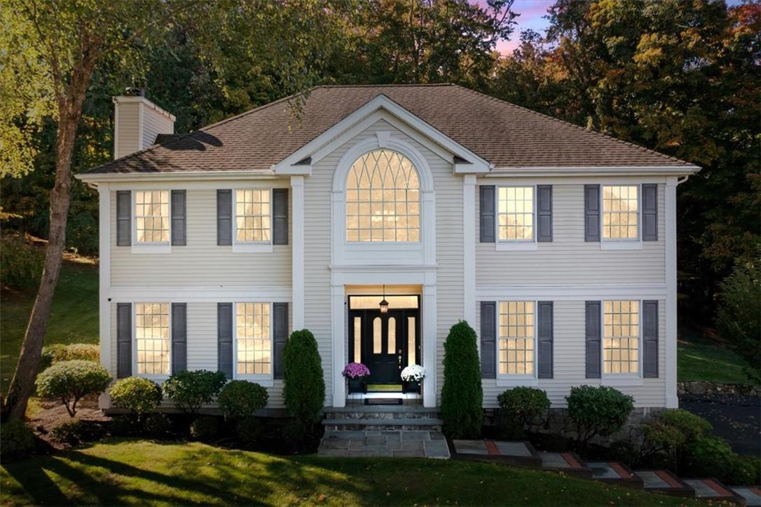 Colonial inspired home featuring a yard