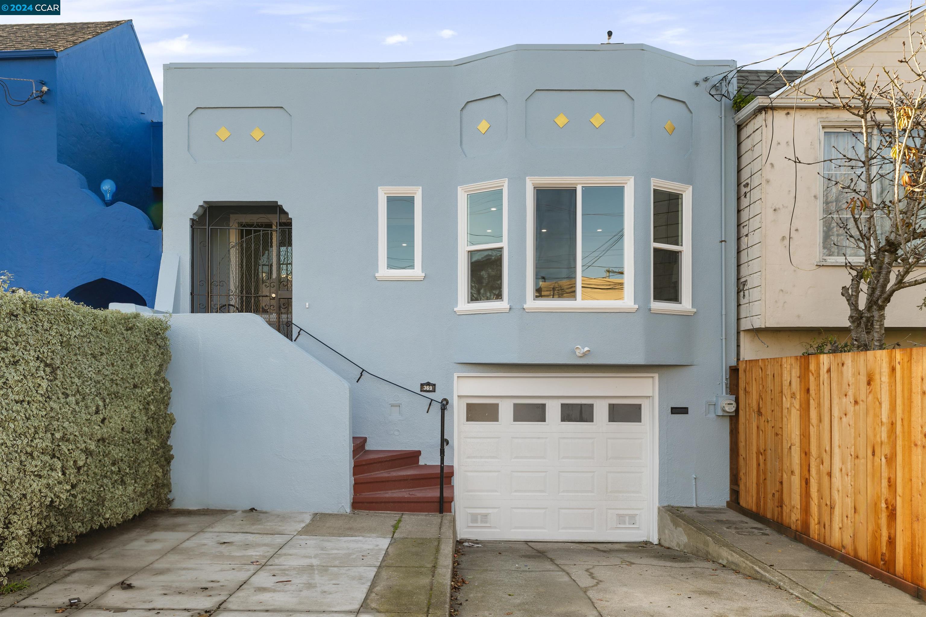 a view of a blue house with large windows