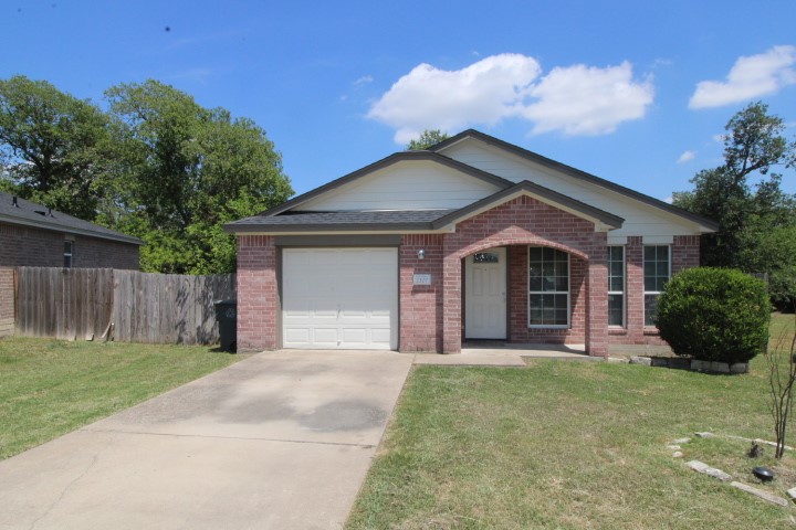 a front view of a house with a garden and yard