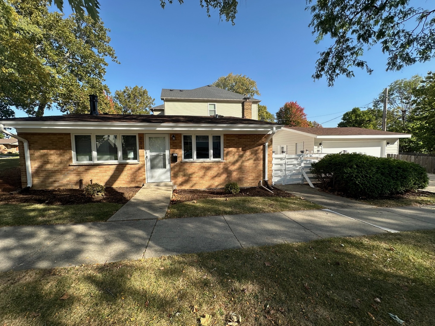 a front view of a house with a yard and potted plants