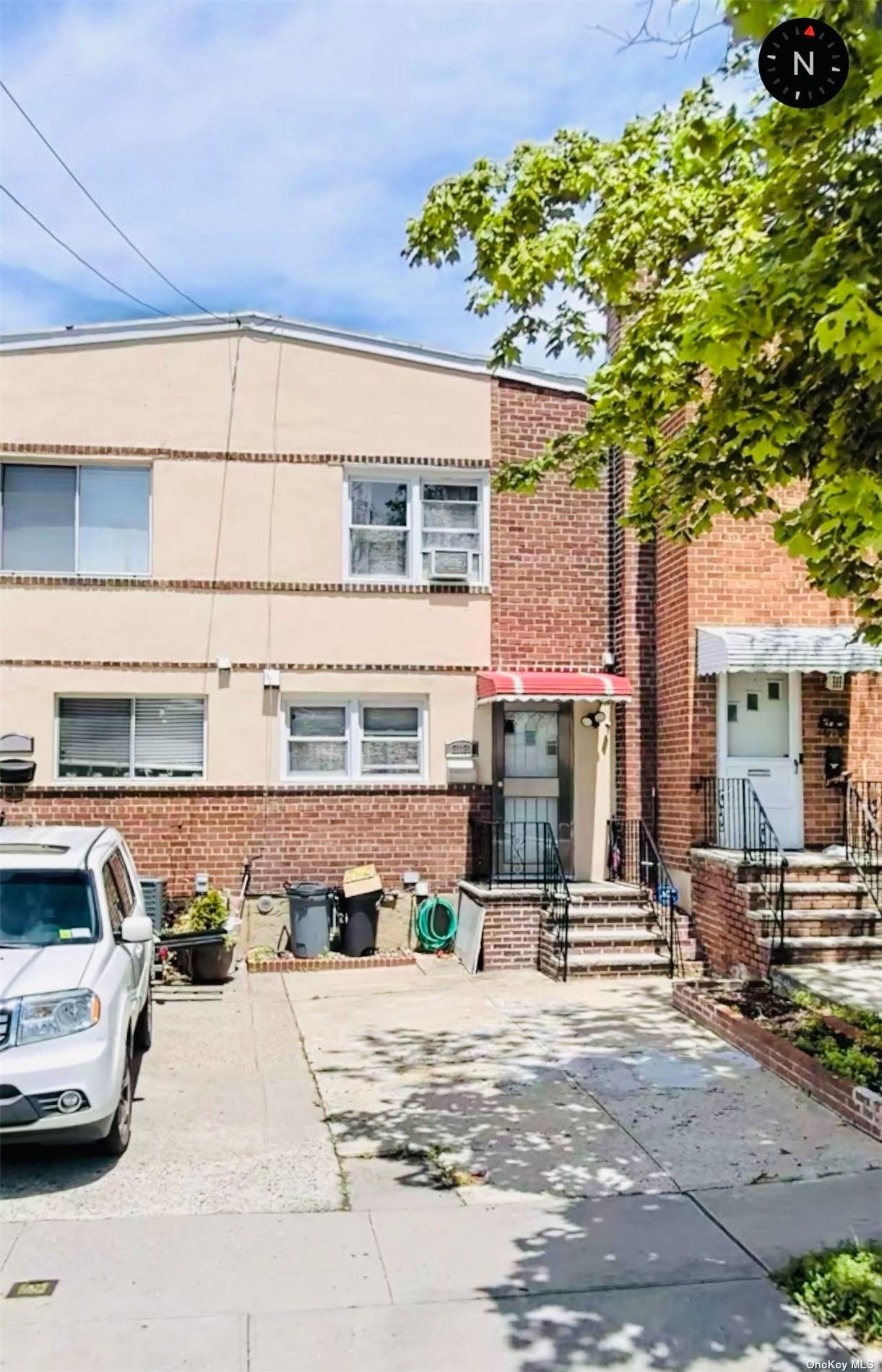 a front view of a building with cars parked