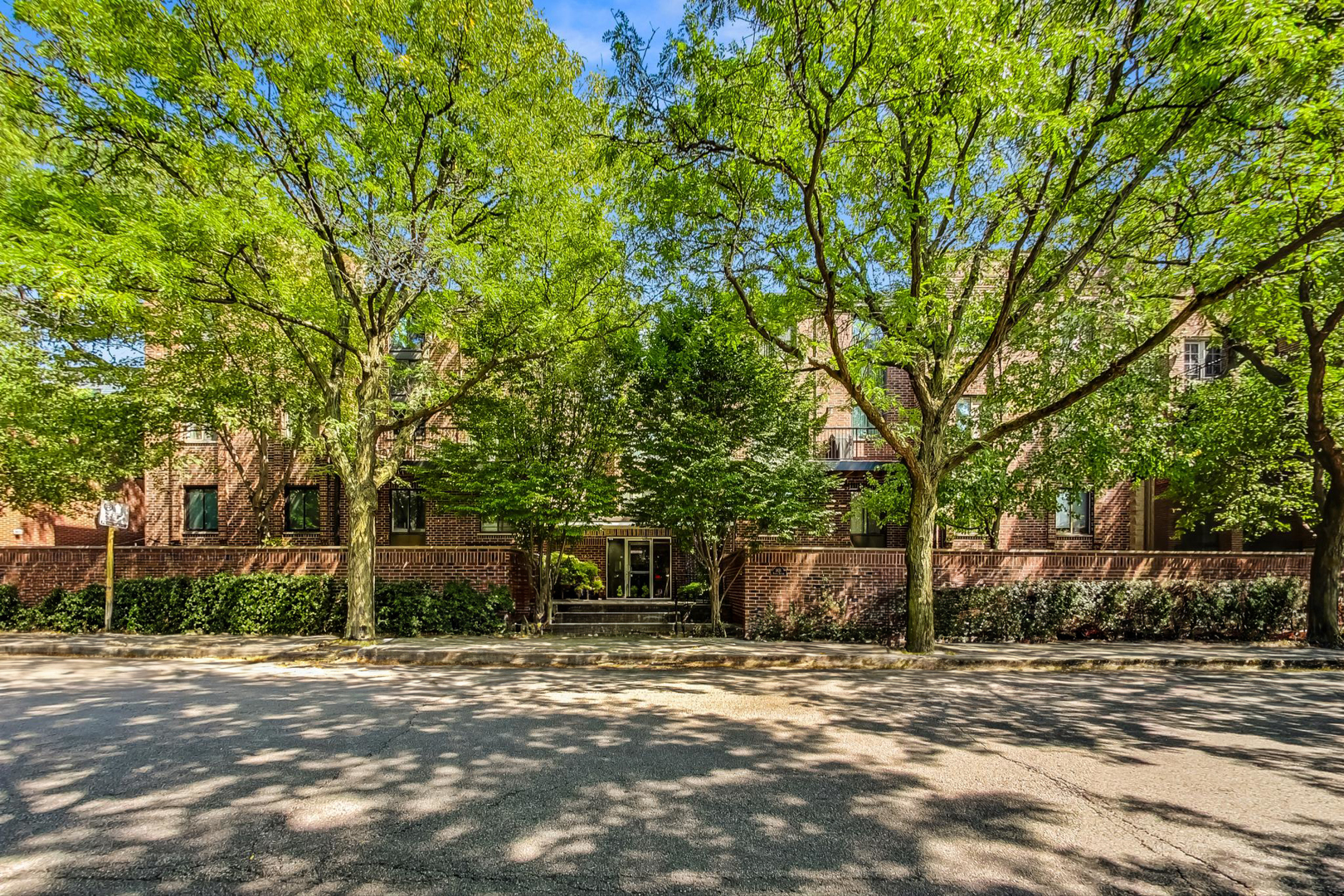 a front view of a house with a yard and tree s