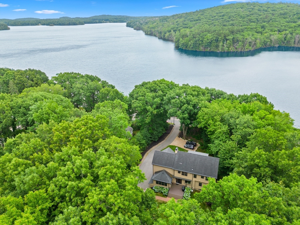 an aerial view of a house with a yard and lake view