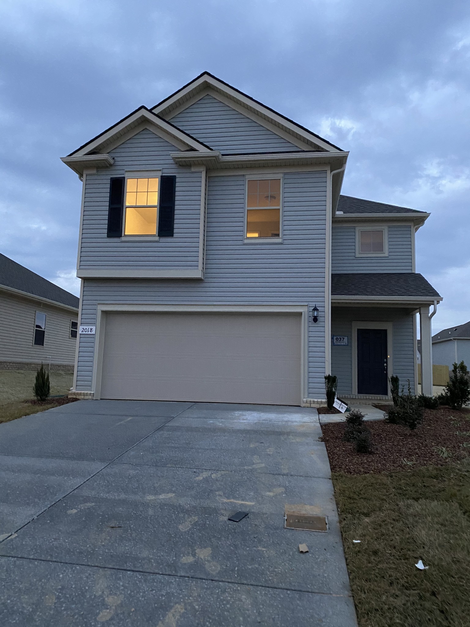 a front view of a house with yard and parking space