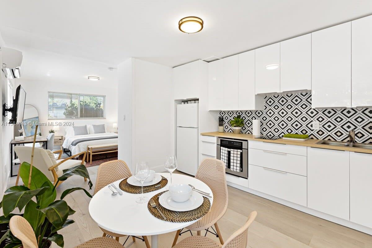 a kitchen with stainless steel appliances granite countertop a white table and chairs