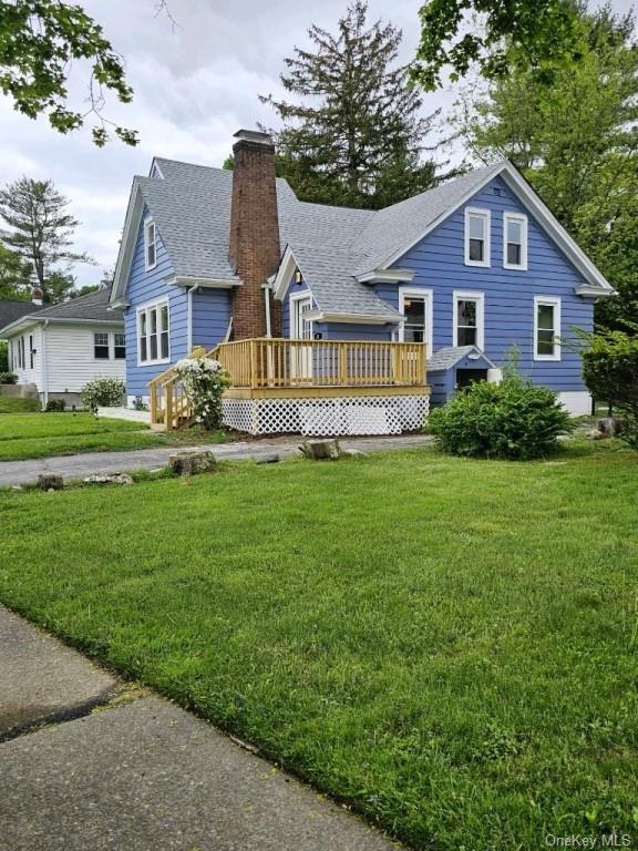 Rear view of house with a deck and a yard