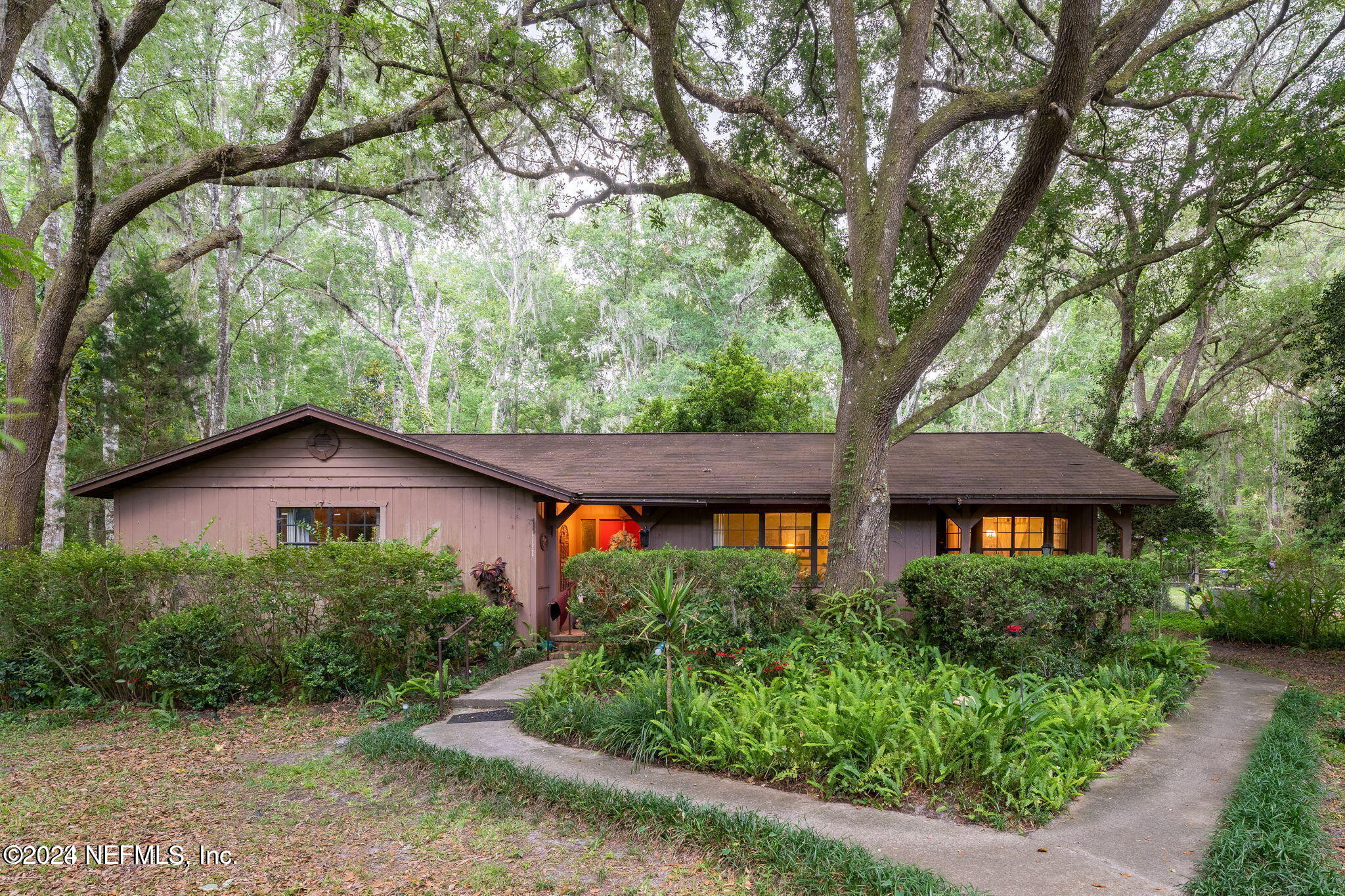 a front view of a house with yard and green space