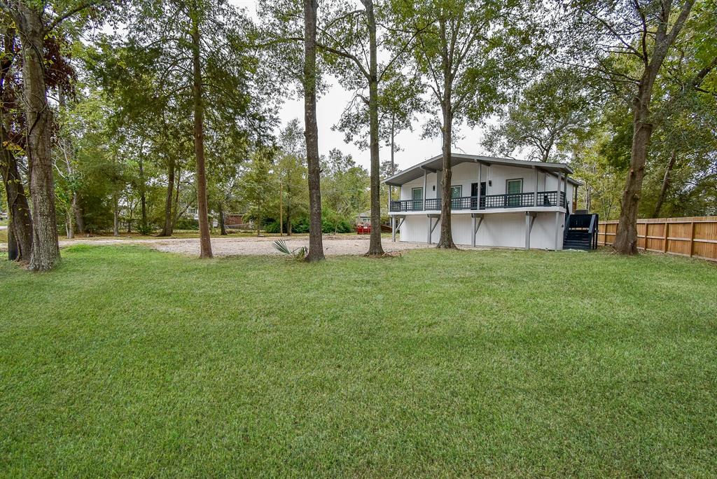 a view of a house with a big yard and large trees