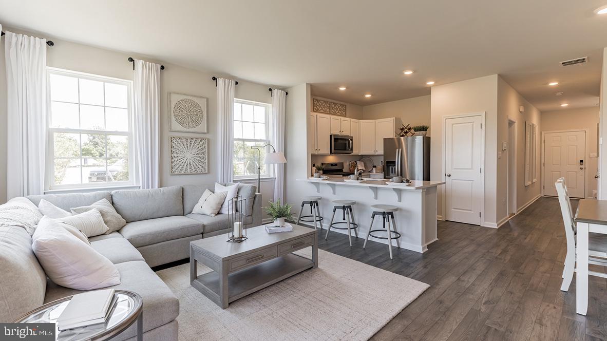 a living room with furniture wooden floor and a view of kitchen