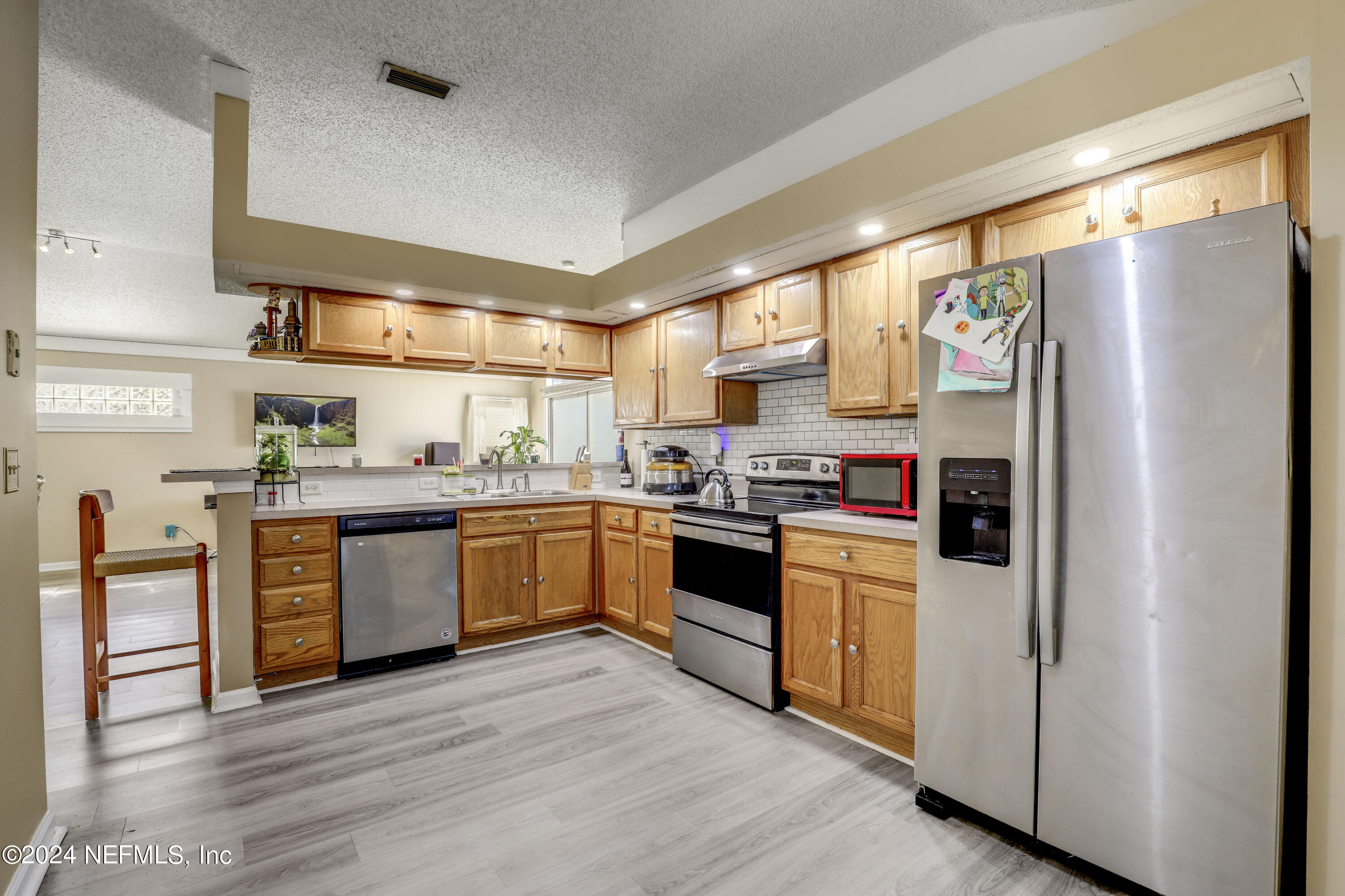 a kitchen with stainless steel appliances granite countertop a refrigerator and a stove top oven