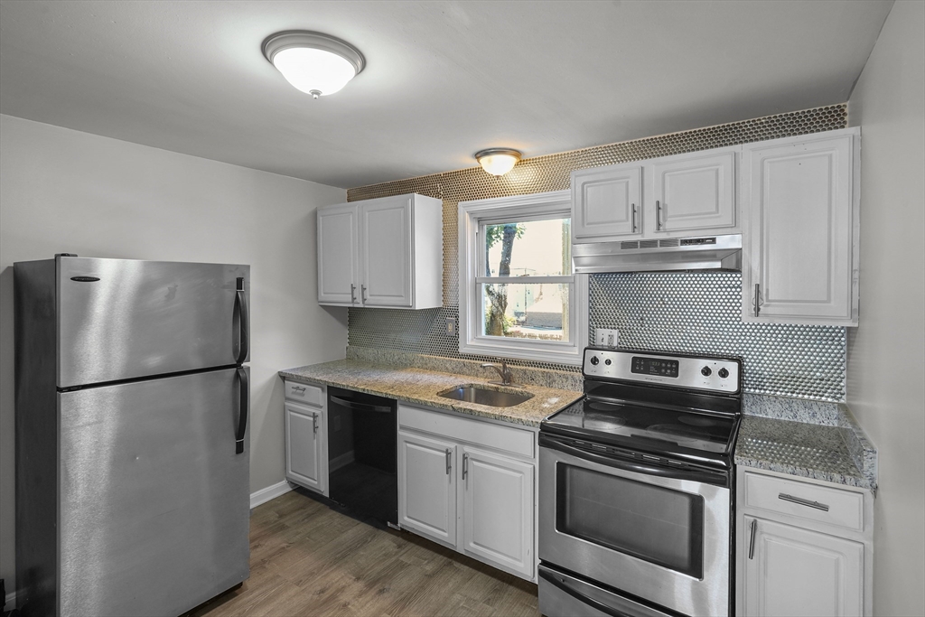 a kitchen with a refrigerator sink and cabinets