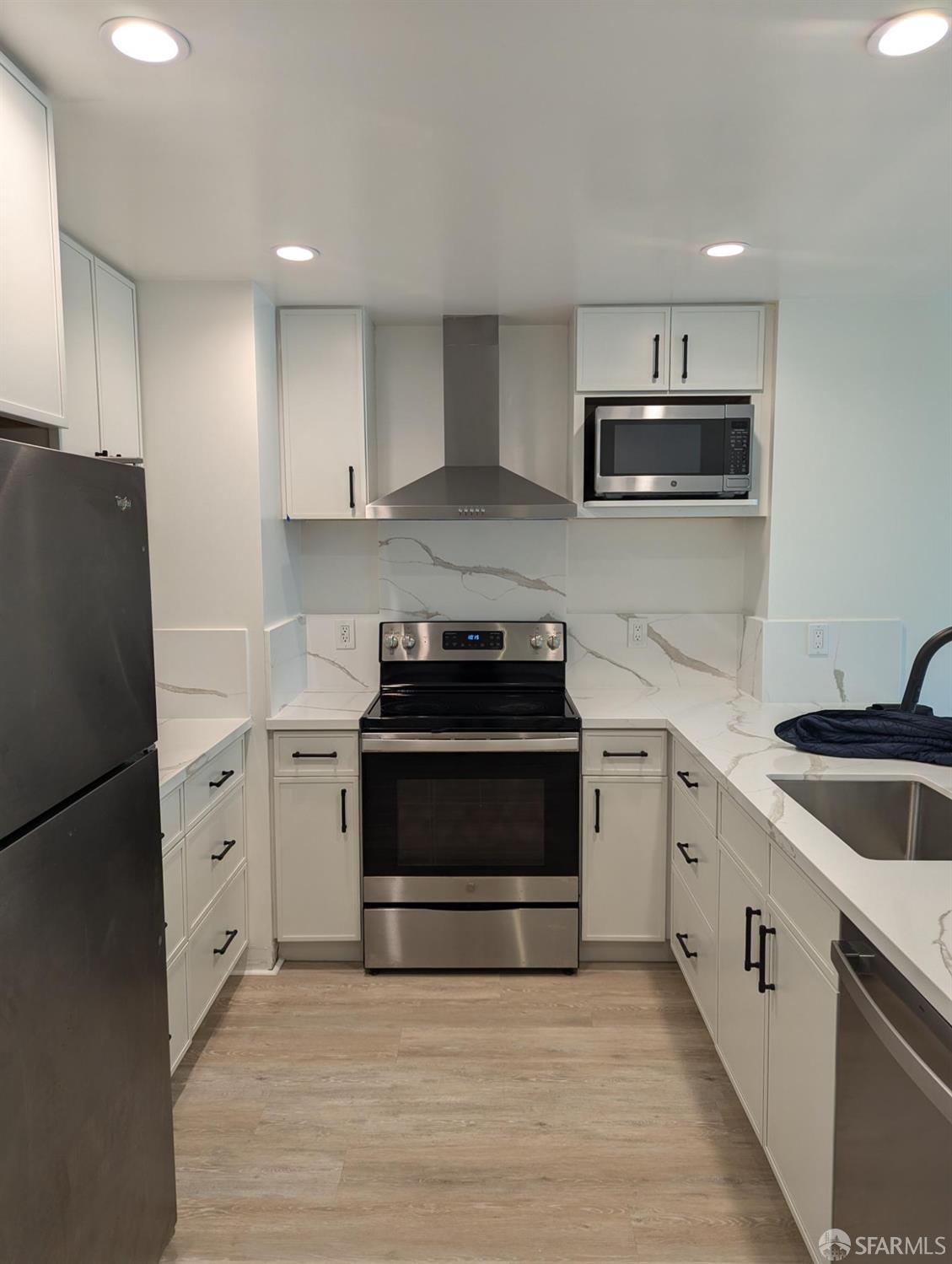 a kitchen with white cabinets and stainless steel appliances