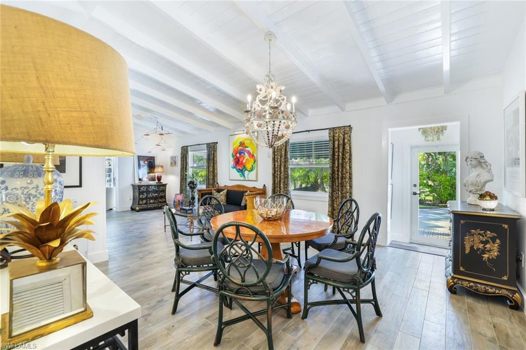 a view of a dining room with furniture a chandelier and wooden floor