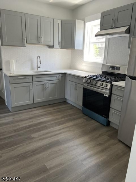 a kitchen with stainless steel appliances granite countertop a sink stove and cabinets