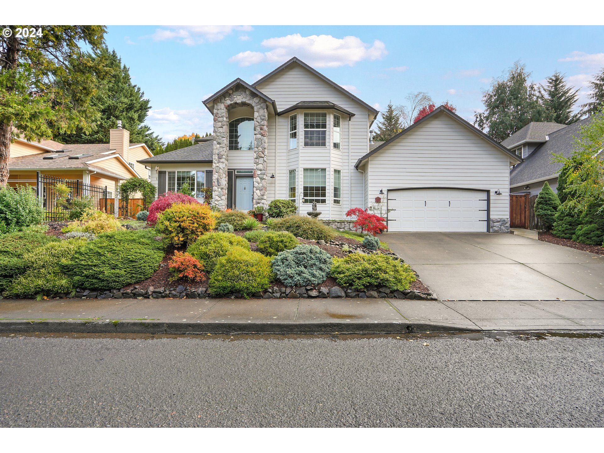 a front view of a house with a yard and potted plants