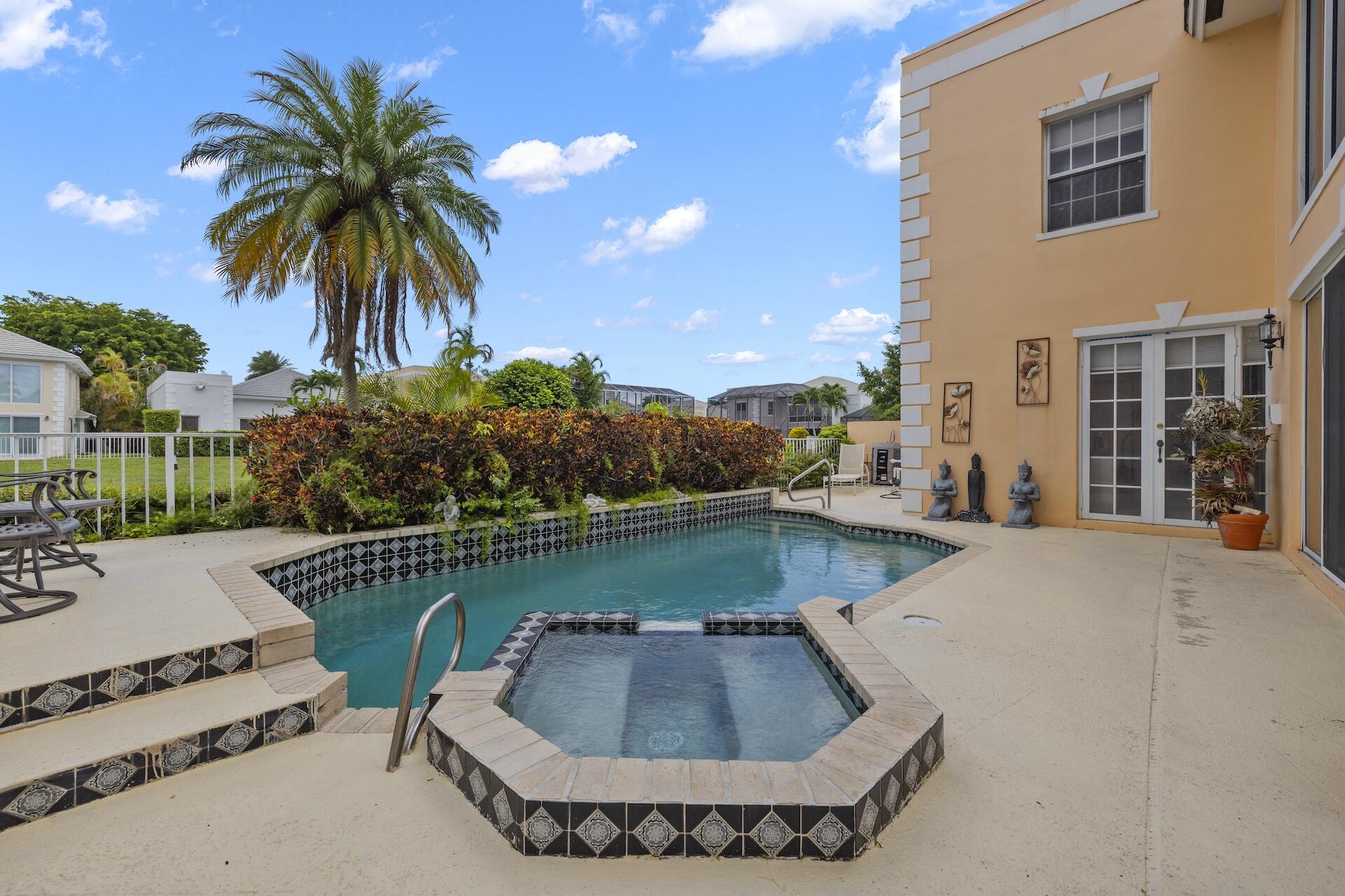 a view of a swimming pool with a patio and a yard