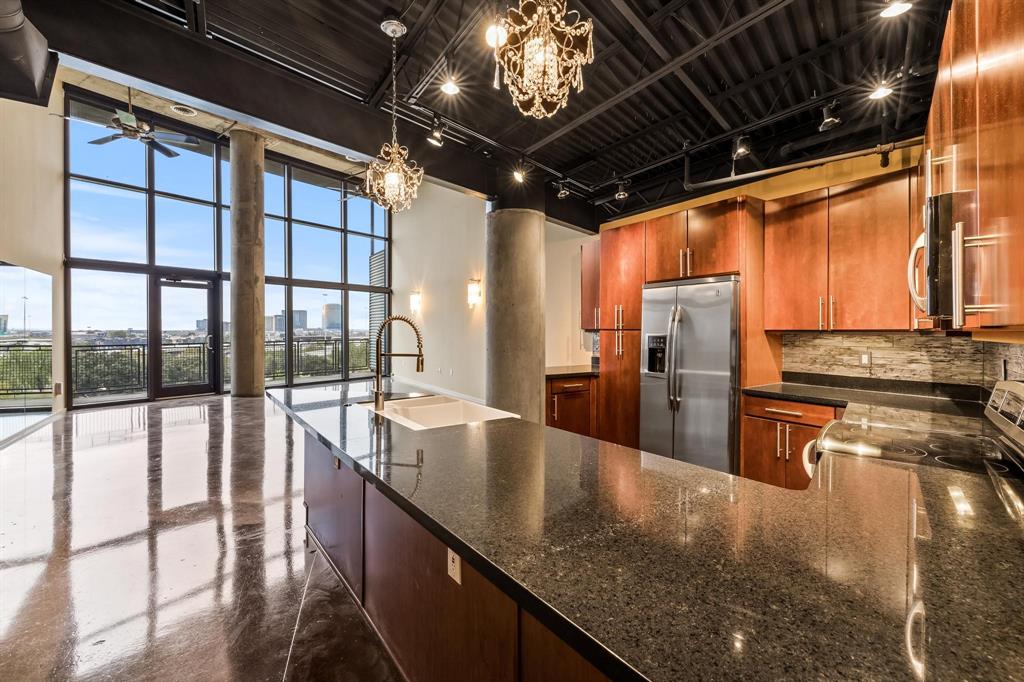 a kitchen with stainless steel appliances granite countertop a sink a counter top and stove