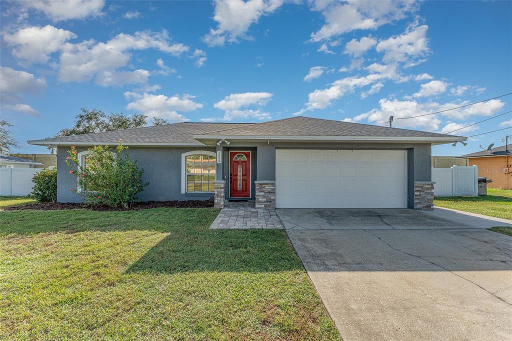 a front view of a house with a yard and garage