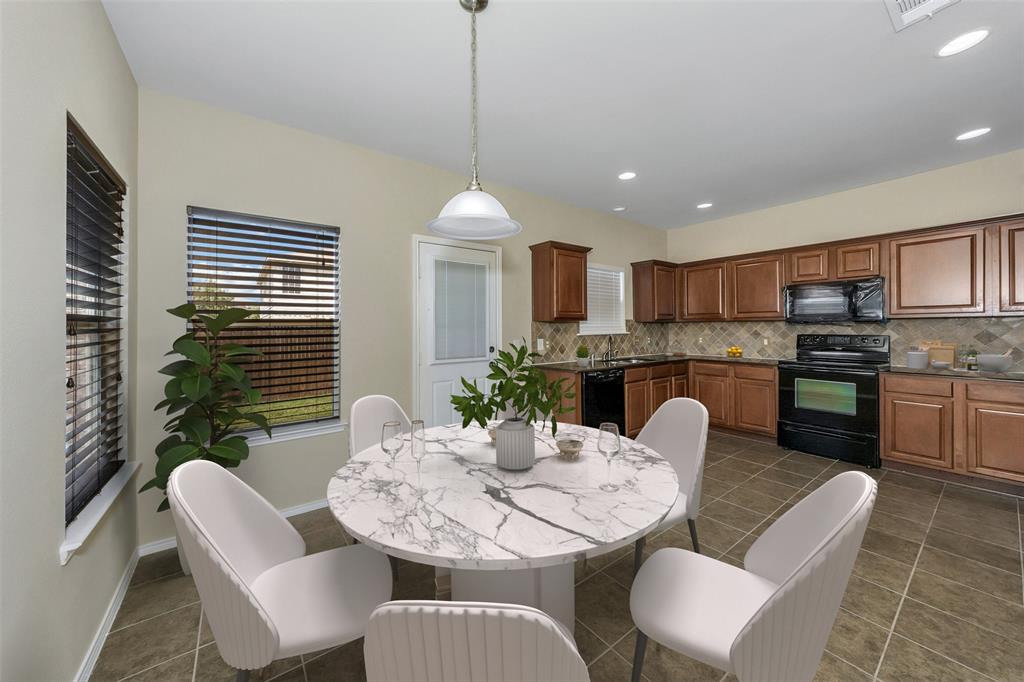 a kitchen with kitchen island granite countertop a dining table chairs and white cabinets