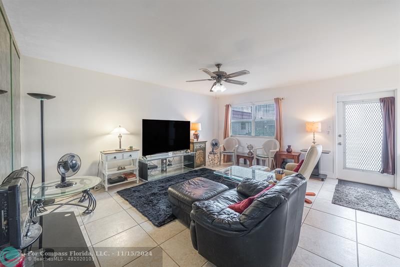 a living room with furniture a flat screen tv and a large window