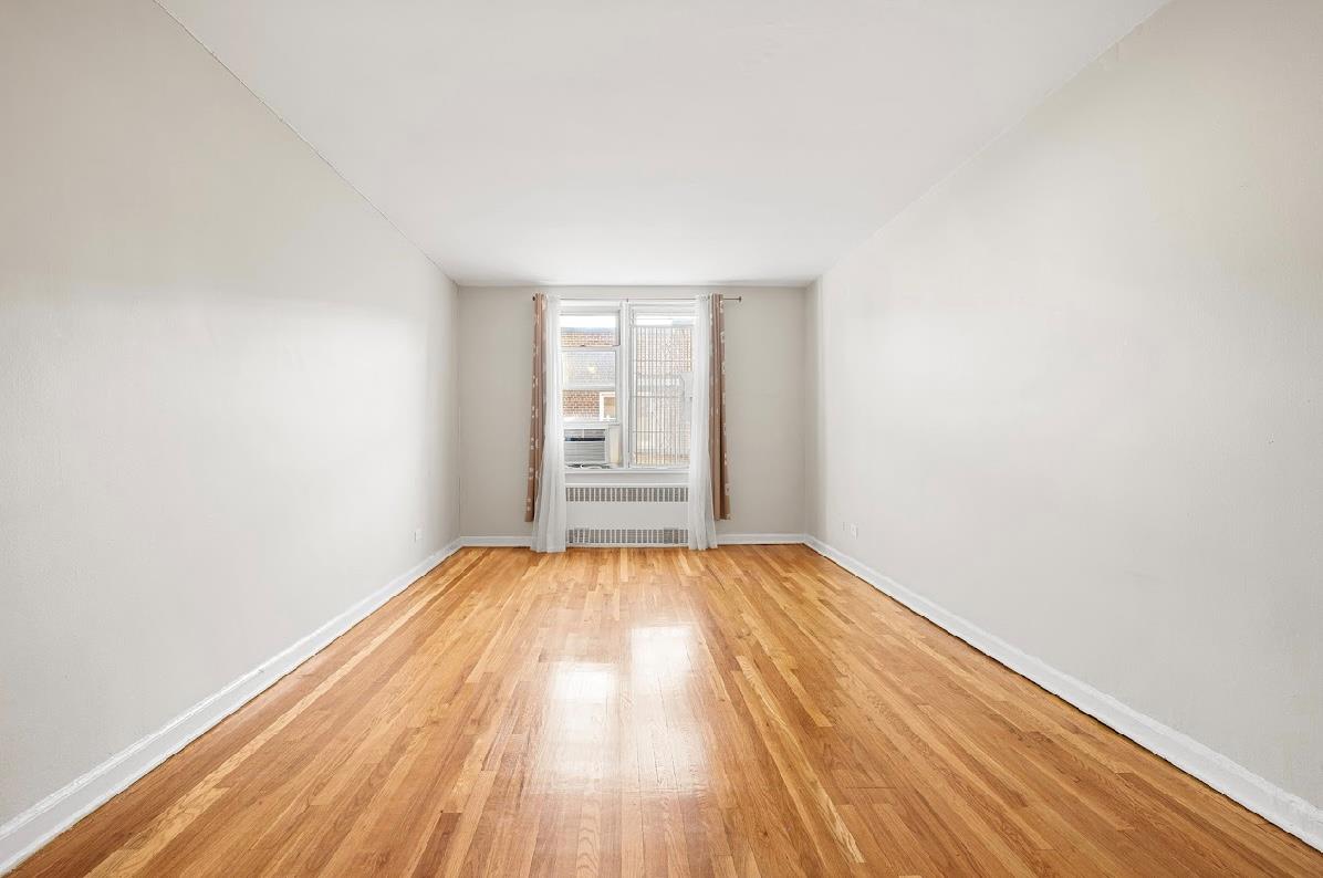 Spare room with light wood-type flooring and radiator heating unit