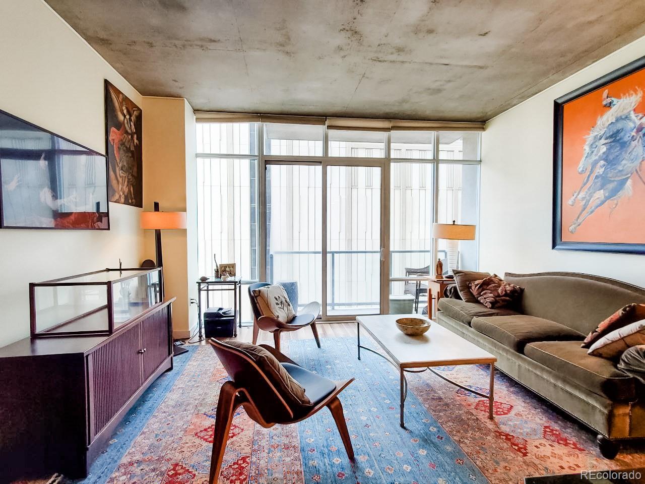 a living room with furniture and a floor to ceiling window