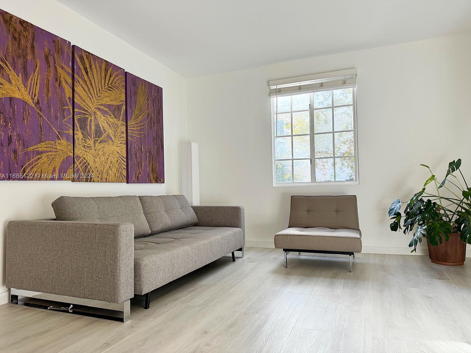 a living room with furniture and a potted plant