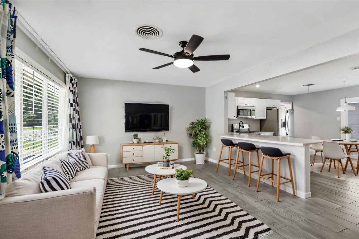 a living room with furniture a flat screen tv and a large window