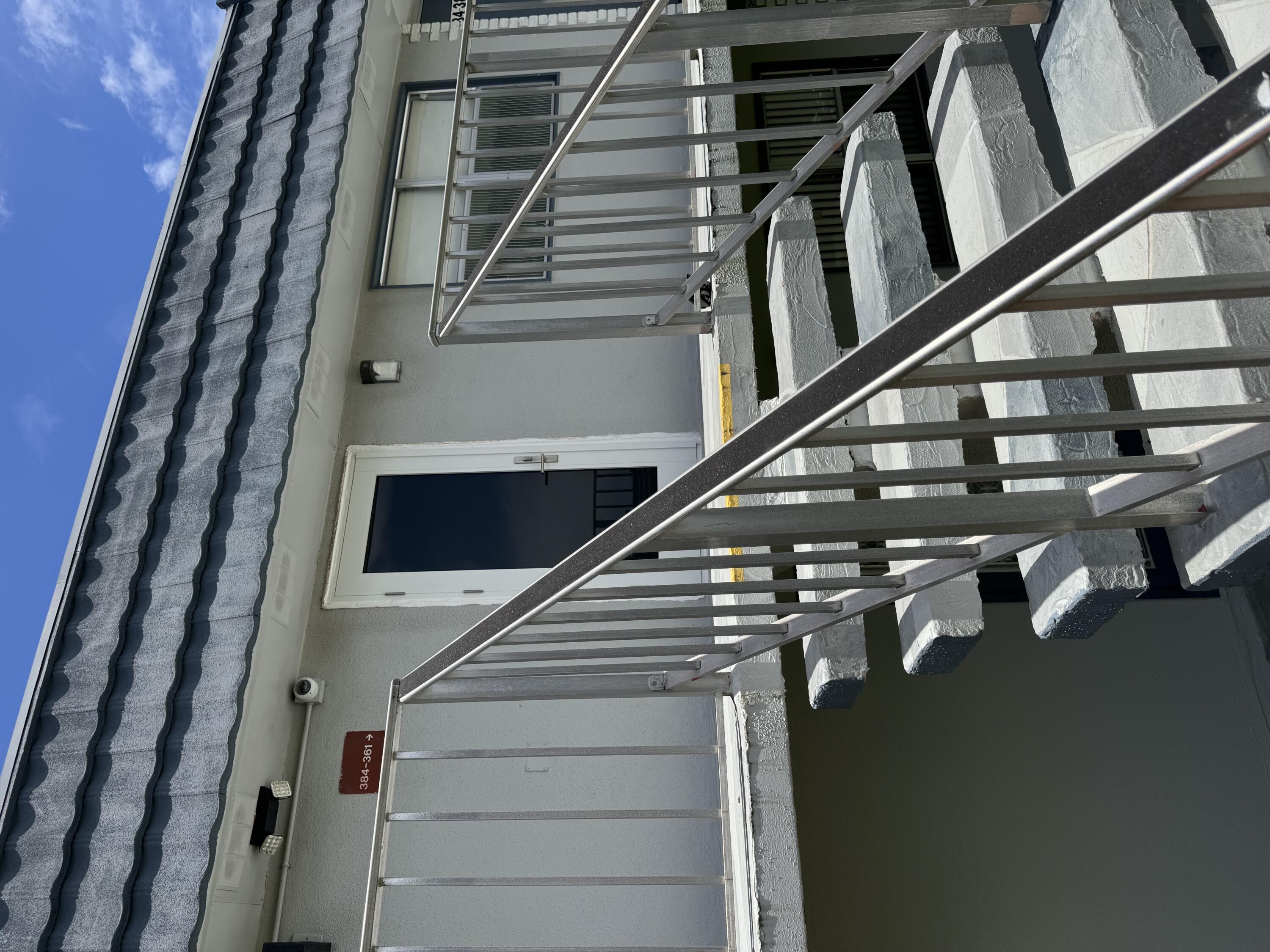 a view of staircase with railing and white walls