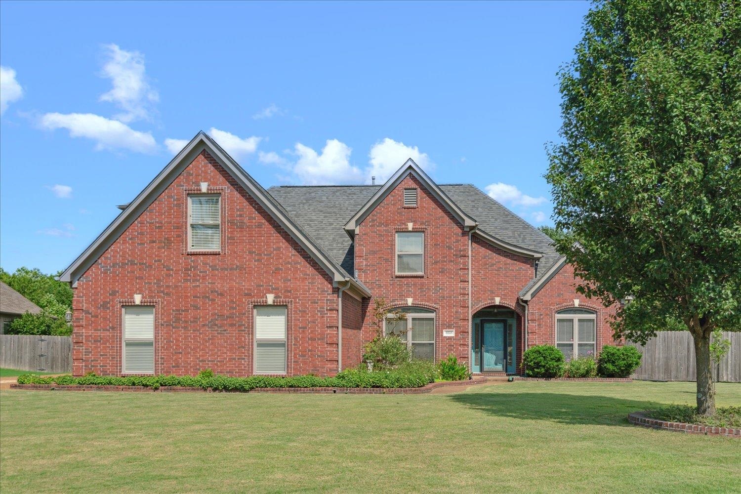 a front view of house with yard and green space