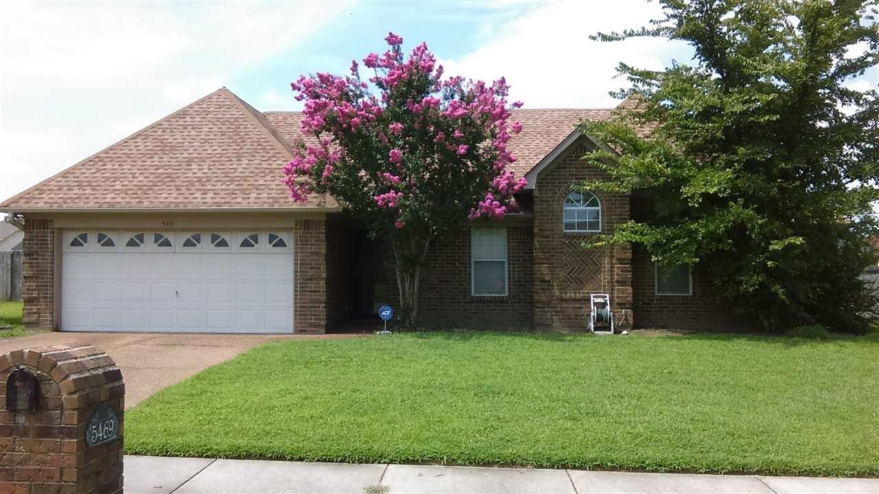 View of front facade featuring a garage and a front lawn