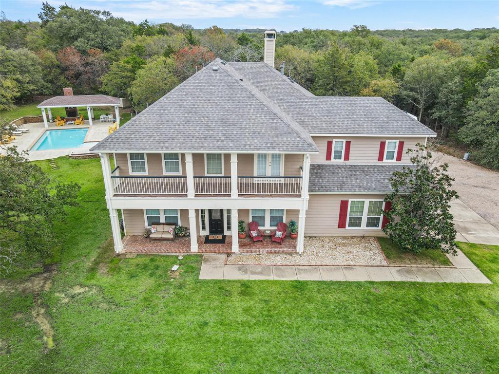 a aerial view of a house with a yard table and chairs