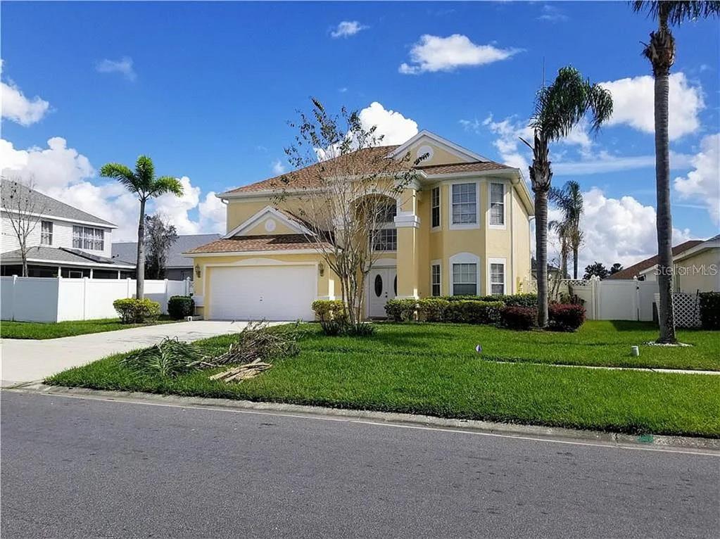 a front view of a house with a yard and potted plants