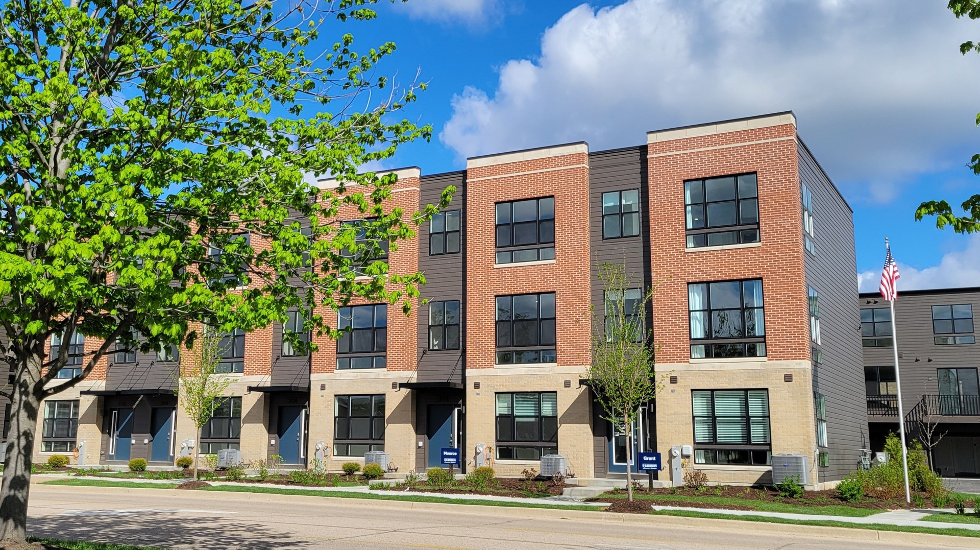 a front view of a multi story building with a yard